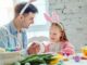 Father And Daughter Making Easter Decorations